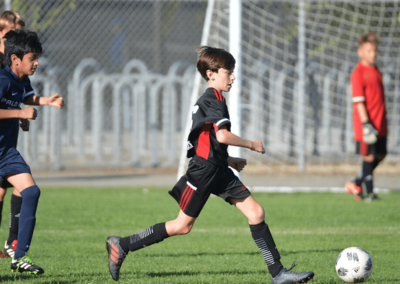 Boys soccer player dribbles the ball